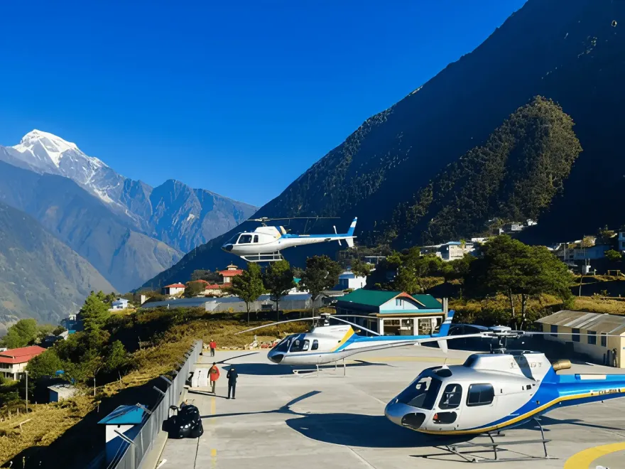 A close-up view of a silver helicopter landed on a snowy plateau at a high-altitude site in the Himalayas with mountain peaks and camping tents in the background.